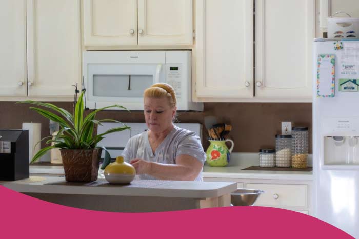 A Guardian Angel Home Care staff member preparing nutritious, home-cooked meals in a clean, modern residential kitchen. The setting highlights the facility’s commitment to providing a familiar, family-oriented atmosphere for its residents.